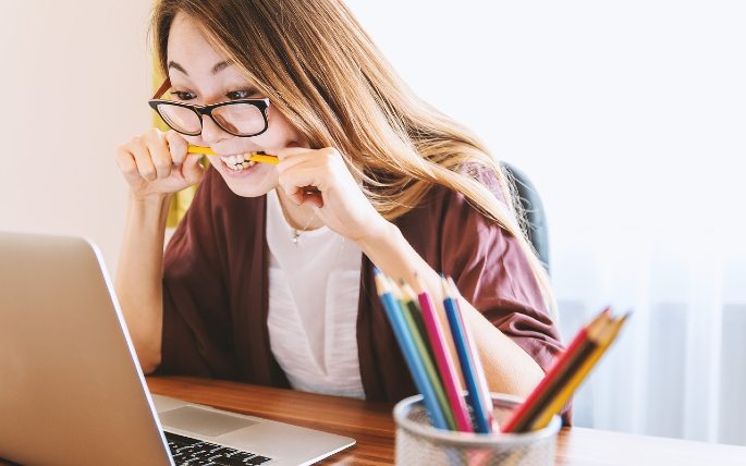 seorang wanita tengah bekerja dengan laptopnya