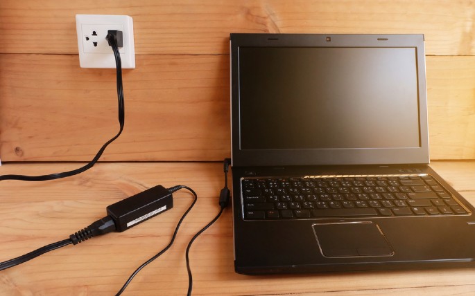 sebuah laptop tengah diberi daya listrik