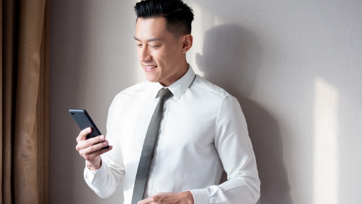 Seorang pria tengah memainkan ponsel (Shutterstock).