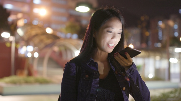 Seorang wanita sedang menerima panggilan saat di jalan (Shutterstock).