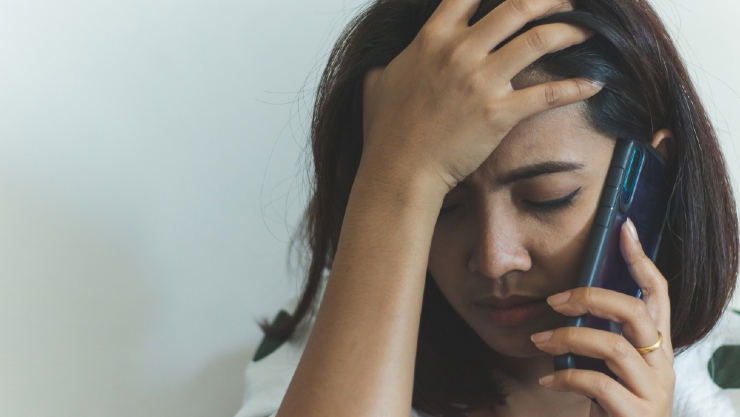Seorang wanita sedang sakit dan menerima telepon (Shutterstock).