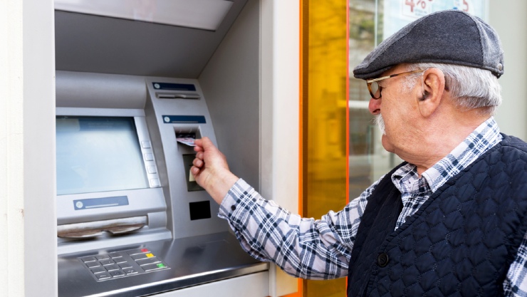 Pria paruh bayar saat melakukan transaksi di ATM