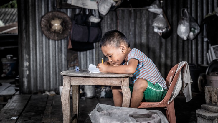 Seorang anak laki-laki tengah belajar di rumahnya (Shutterstock).