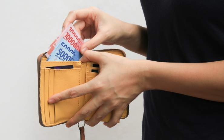 seorang wanita akan mengeluarkan uang dari dompet