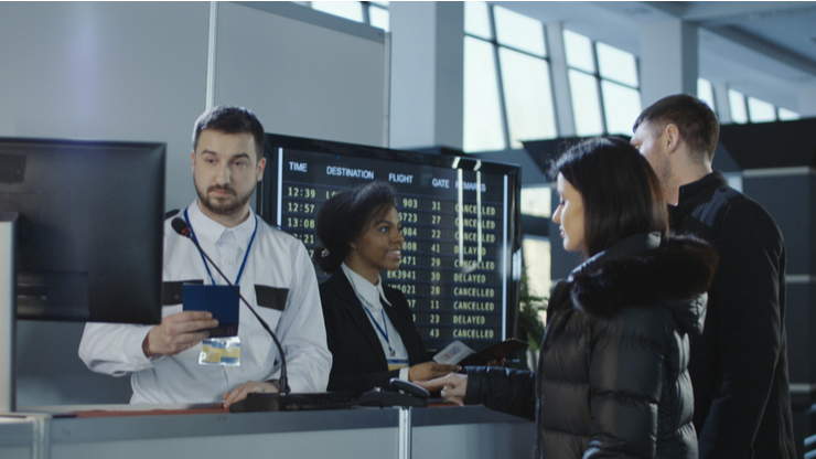 Bagian imigrasi sedang memeriksa pengunjung yang keluar masuk di bandara (Shutterstock).