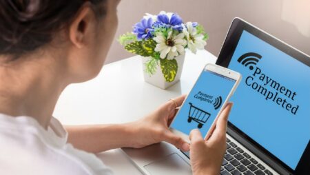 bertransaksi dengan ponsel pintar dan laptop