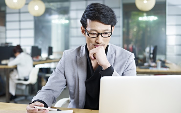 seorang pekerja pria sedang bekerja di depan laptop