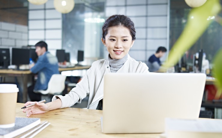 seorang pekerja wanita sedang bekerja di depan laptopnya