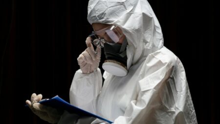 orang menggunakan pakaian pelindung dari virus