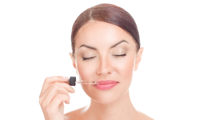 Seorang wanita tengah menggunakan lip serum (Shutterstock).