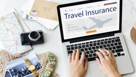 orang melihat asuransi perjalanan di laptop