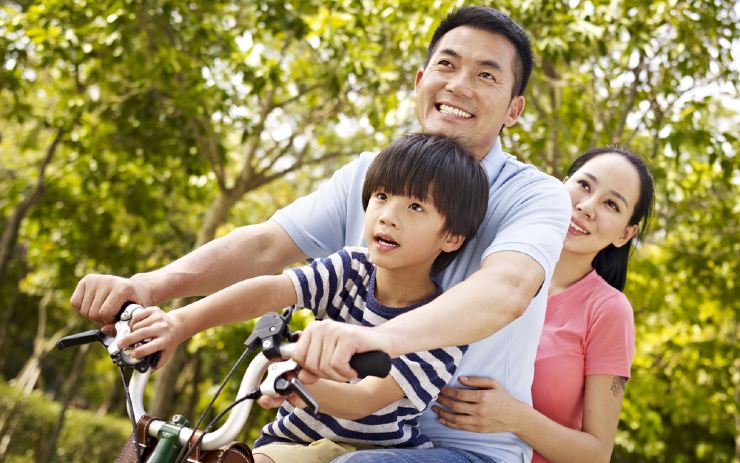 Pasangan suami istri dengan satu anak tengah naik sepeda