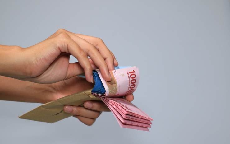 seseorang menghitung uang rupiah