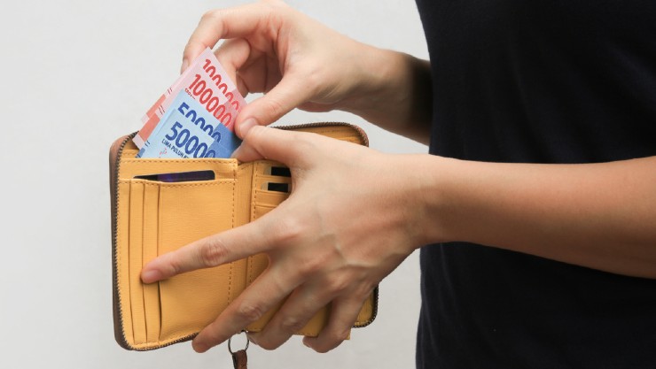 Melongok uang dalam dompet (Shutterstock).
