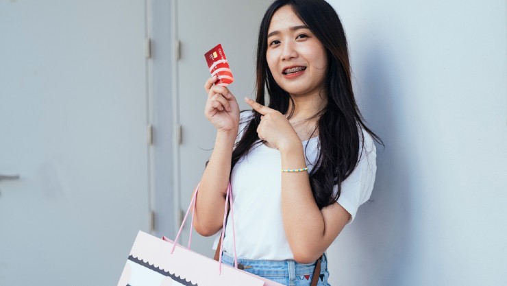 Seorang wanita berbelanja dengan kartu kredit (Shutterstock).