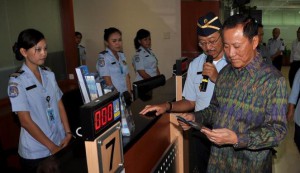 Lihat ini petugas imigrasi berseragam biru, lengkap dengan atribut identitas nama dan pangkat.